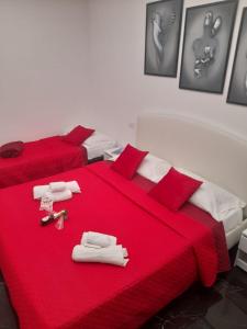 a bedroom with two beds with red sheets and towels at Lux House Naples Airport in Naples