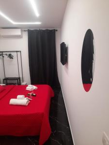 a room with a red bed and a mirror at Lux House Naples Airport in Naples