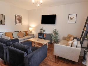 a living room with a couch and a tv at The Pheasantry in Bridlington
