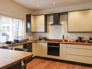a kitchen with white cabinets and a wooden counter top at The Pheasantry in Bridlington