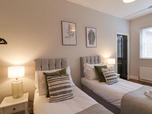 a bedroom with two beds and a table with lamps at The Pheasantry in Bridlington