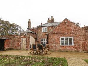 a brick house with chairs in front of it at The Pheasantry in Bridlington