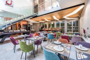 a restaurant with tables and chairs and a staircase at Hôtel B55 in Paris