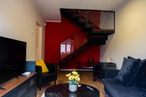una sala de estar con una pared roja y una escalera en FLH Alcântara Stylish Duplex with Terrace, en Lisboa