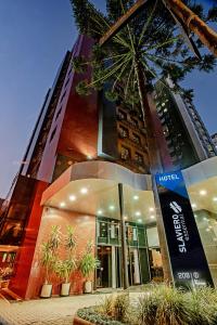 a building with a sign in front of it at Slaviero Curitiba Shopping in Curitiba