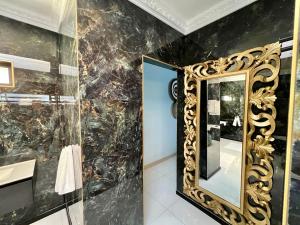 a gold mirror on a wall next to a bathroom at The Presidential at Forty 4 On Hoog Street in Polokwane +22 photos