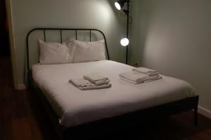 Una cama con sábanas blancas y toallas. en FLH Alcântara Stylish Duplex with Terrace, en Lisboa
