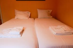 2 camas con sábanas blancas y toallas. en FLH Alcântara Stylish Duplex with Terrace, en Lisboa