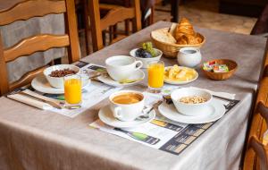 un tavolo ricoperto di tazze di caffè e prodotti per la colazione di Contact Hotel Du Ladhof a Colmar