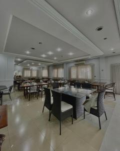 a dining room with tables and chairs in a restaurant at Marion Pantanal Hotel in Várzea Grande