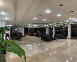 a lobby with couches and a table and chairs at Marion Pantanal Hotel in Várzea Grande