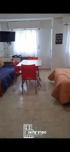 a living room with a table and chairs and a bed at Center Studio 3pax apartamento in Trelew