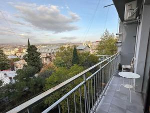 a balcony with a table and a view of a city at Panoramic View Apart Vera 67 in Tbilisi City