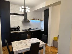 a kitchen with a table and a kitchen with a stove at Panoramic View Apart Vera 67 in Tbilisi City +18 photos