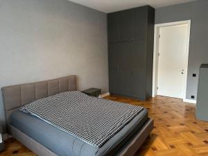 a bedroom with a bed in a room with wooden floors at Panoramic View Apart Vera 67 in Tbilisi City