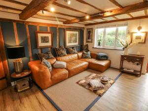 a living room with a brown leather couch at Pen Y Groes in Welshpool