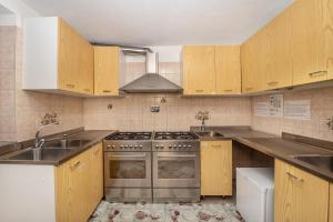 a kitchen with wooden cabinets and a stove top oven at Agriturismo La Clochette in Torgnon