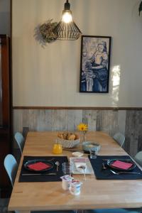 a dining room table with a painting on the wall at Les hirondelles du moulin in Sassay