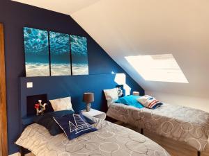 Duas camas num quarto com paredes e janelas azuis em LA MARIEFACTURE - Comme un Poisson dans l'eau em Saint-Avold