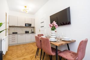 a kitchen and dining room with a table and chairs at Gallery 7 - Apartment 7 in Krakow