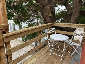 two chairs and a table on a deck with a tree at Elegant 1 Bdr Montrose-Bologna@The Italian Plaza in Houston