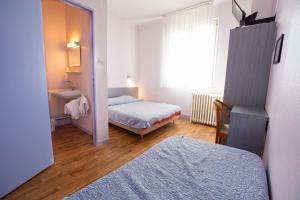 コルマールにあるホテル デュ ラドホフのベッド2台と窓が備わる小さな客室です。