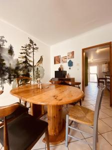 una sala da pranzo con tavolo e sedie in legno di LA MARIEFACTURE - Comme en forêt a Saint-Avold