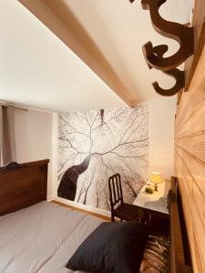 una camera da letto con un murale di un albero di LA MARIEFACTURE - Comme en forêt a Saint-Avold