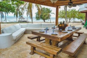 ein Wohnzimmer mit einem Sofa, einem Tisch und Bänken in der Unterkunft Villa en Barú con playa privada 6BR in Barú