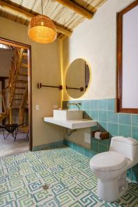 a bathroom with a toilet and a sink and a mirror at Casa Mambo Salinas in Santa Veronica