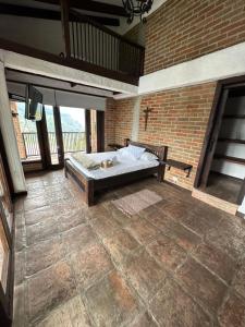 um quarto com uma cama numa parede de tijolos em Hotel Boutique Villa Isabel em Salento