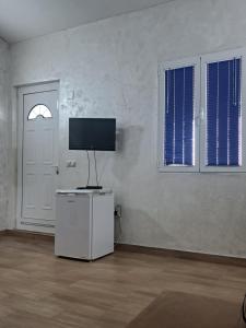 a white room with a tv on top of a refrigerator at Diamond by EXCLUSIVE Collection Sea view apartments in Dobra Voda