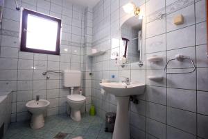 ein Badezimmer mit einem Waschbecken, einem WC und einem Spiegel in der Unterkunft Romansa in Pale