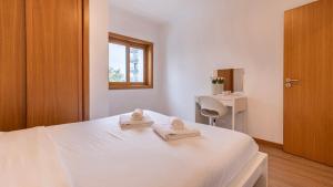 ein Schlafzimmer mit einem weißen Bett mit zwei Handtüchern darauf in der Unterkunft 3 Bedroom Oeiras Wonder W/ Balcony by LovelyStay in Oeiras