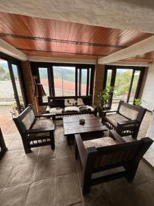 - un salon avec des tables, des chaises et des fenêtres dans l'établissement Hotel Boutique Villa Isabel, à Salento