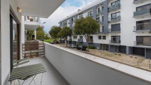 einen Balkon eines Apartmenthauses mit einer Bank in der Unterkunft 3 Bedroom Oeiras Wonder W/ Balcony by LovelyStay in Oeiras