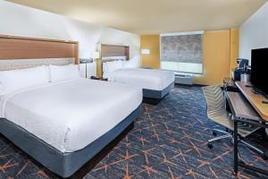 Cette chambre comprend deux lits et un bureau. dans l'établissement Holiday Inn Hotel & Suites Tulsa South, an IHG Hotel, à Tulsa