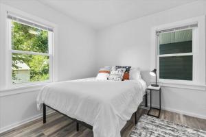 a white bedroom with a bed and two windows at 214: Lovely fully furnished 1 bedroom! in Billings