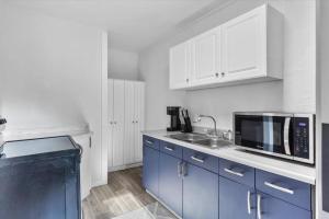 a kitchen with blue cabinets and a microwave at 214: Lovely fully furnished 1 bedroom! in Billings