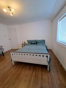um quarto com uma cama grande num quarto branco em GATWICK HOUSE em Crawley