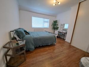 a bedroom with a bed and a table and a desk at GATWICK HOUSE in Crawley