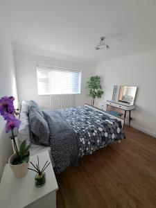 Schlafzimmer mit einem Bett, einem Tisch und einem Fenster in der Unterkunft GATWICK HOUSE in Crawley