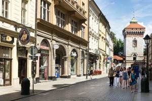 grupa ludzi idących ulicą z budynkami w obiekcie Apartamenty i Studia HERBARIUM w Krakowie
