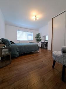 a bedroom with a bed and a table and a chair at GATWICK HOUSE in Crawley