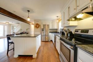 a kitchen with white cabinets and black counter tops at Spacious Oxford Home with Pool - 4 Mi to Lake! 