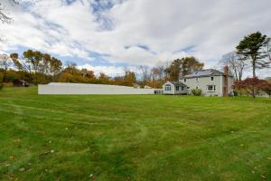 a large yard with a white fence and a house at Spacious Oxford Home with Pool - 4 Mi to Lake! 