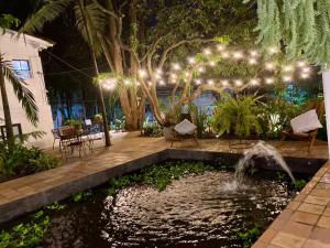 un patio con un estanque y una fuente con luces en Hotel Boutique Quinta Ladera, en Medellín