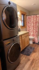 a kitchen with a washing machine with a microwave at Twinn Peaks Beautiful Modern Mountain Cabin Retreat-Cozy-Secluded-WiFi-Pets in Murphy