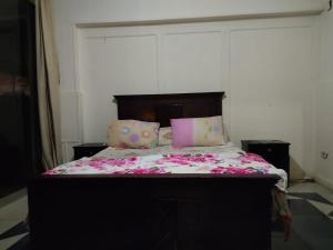 ein Schlafzimmer mit einem großen Bett mit rosa Bettwäsche und Kissen in der Unterkunft شقه شارع 204 in Kairo