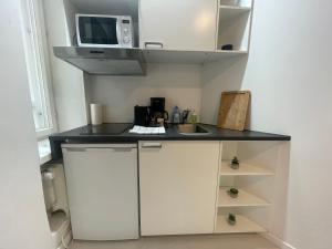 una cucina con piano di lavoro e forno a microonde di Cosy City Central Flat with self check-in a Helsinki